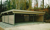 Standard-Carports als Reihenanlage aus BSH Holz, Wände aus Lärche, runde Pfosten in Aluminium; mit dazugehörigem Schuppen mit einer Solux-Trapezplatten Dacheindeckung – in Detmold